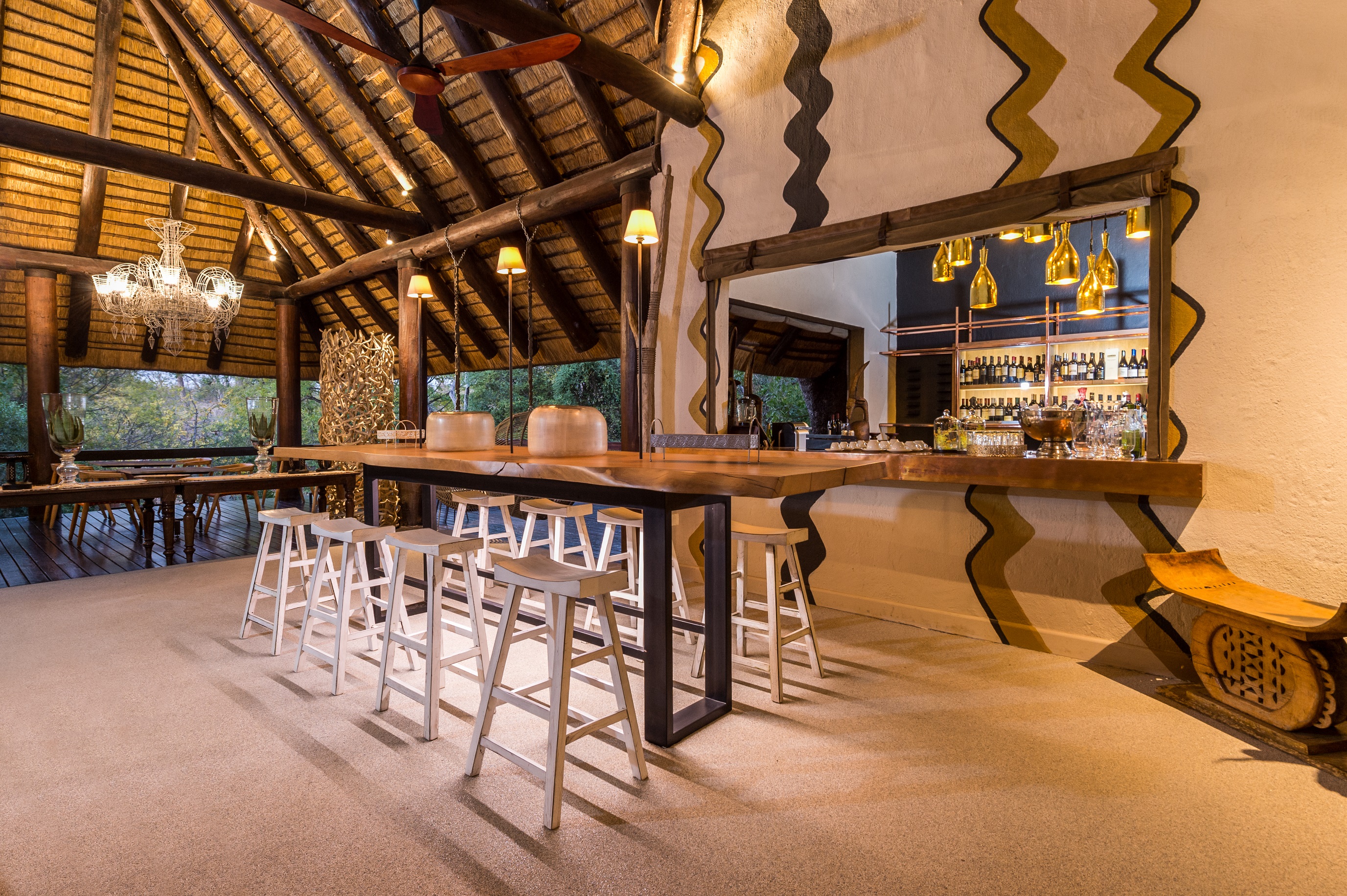 <p>The bar area at Little Bush Camp is decorated with natural materials and African-inspired decor, including traditional woven baskets and artwork depicting local wildlife.</p>